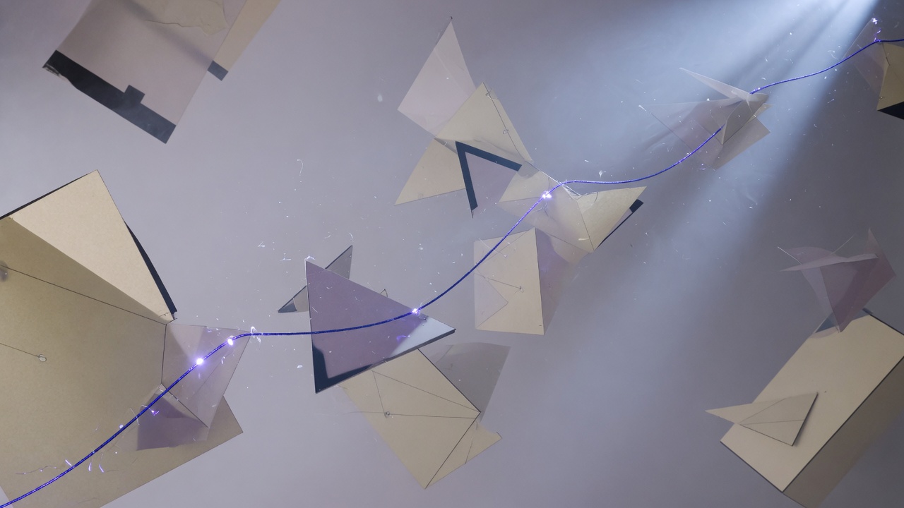 Floating paper planes and geometric sheets bound by a single indigo thread of light