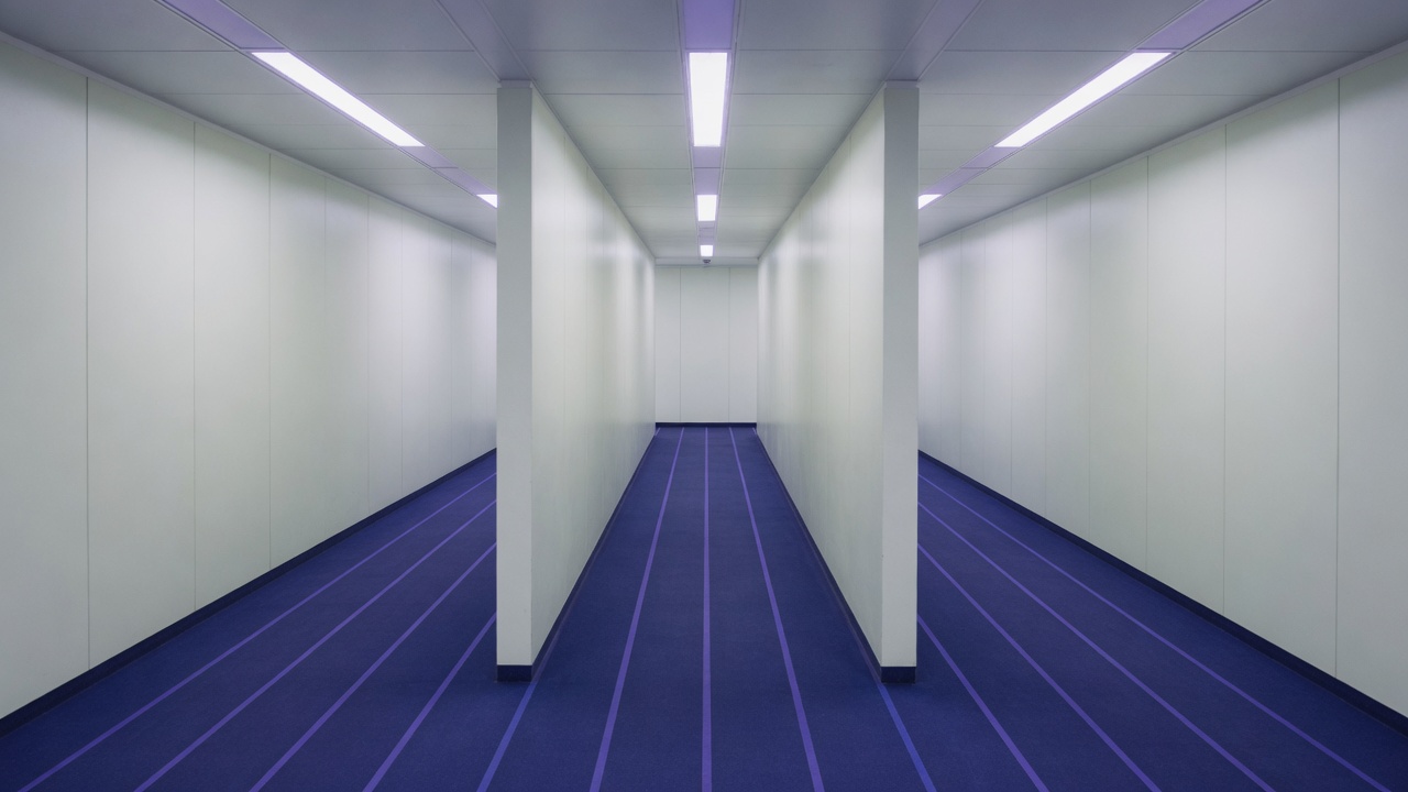 Parallel pale corridors with indigo floor lines diverging