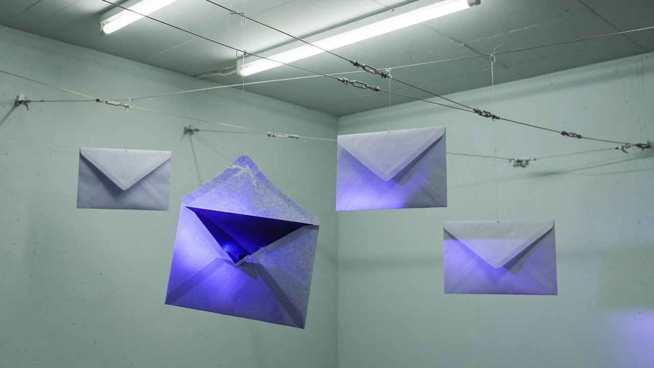 Suspended envelopes, one opening with indigo light