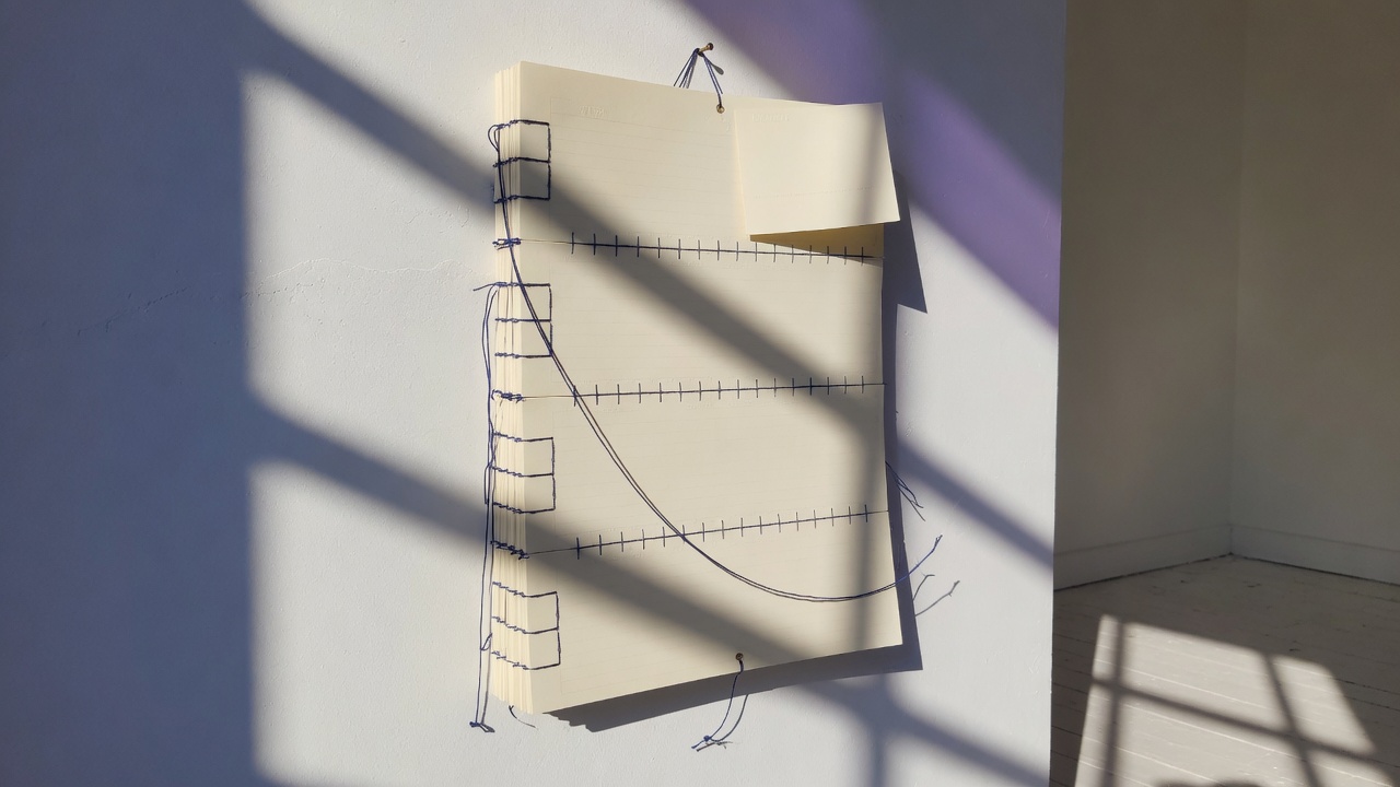 Calendar pages stitched by an indigo thread